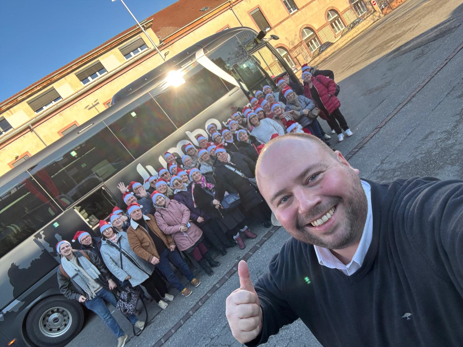 Groupe de voyageurs souriants devant l’autocar Jumbo Tourisme.