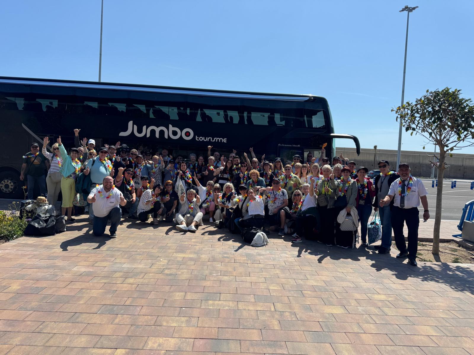 Groupe de voyageurs devant l’autocar Jumbo Tourisme.